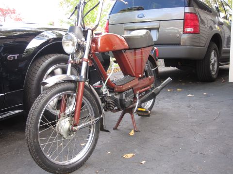 1981 Garelli Rally Sport - A red moped is parked in front of a black Ford Mustang GT and a gray Ford Explorer.