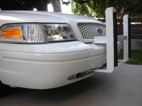 2004 Ford Crown Victoria - The front end of a white Ford Crown Victoria is shown with a white push bumper attached.