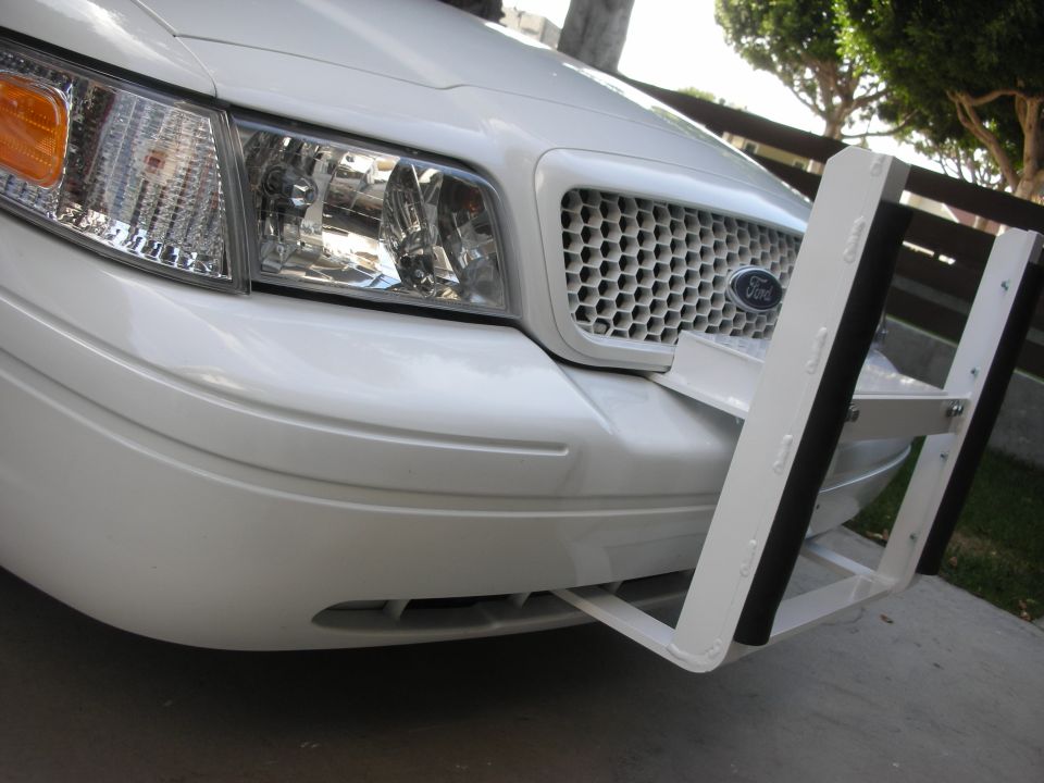 White Ford Crown Victoria front end with white push bar and honeycomb grille
