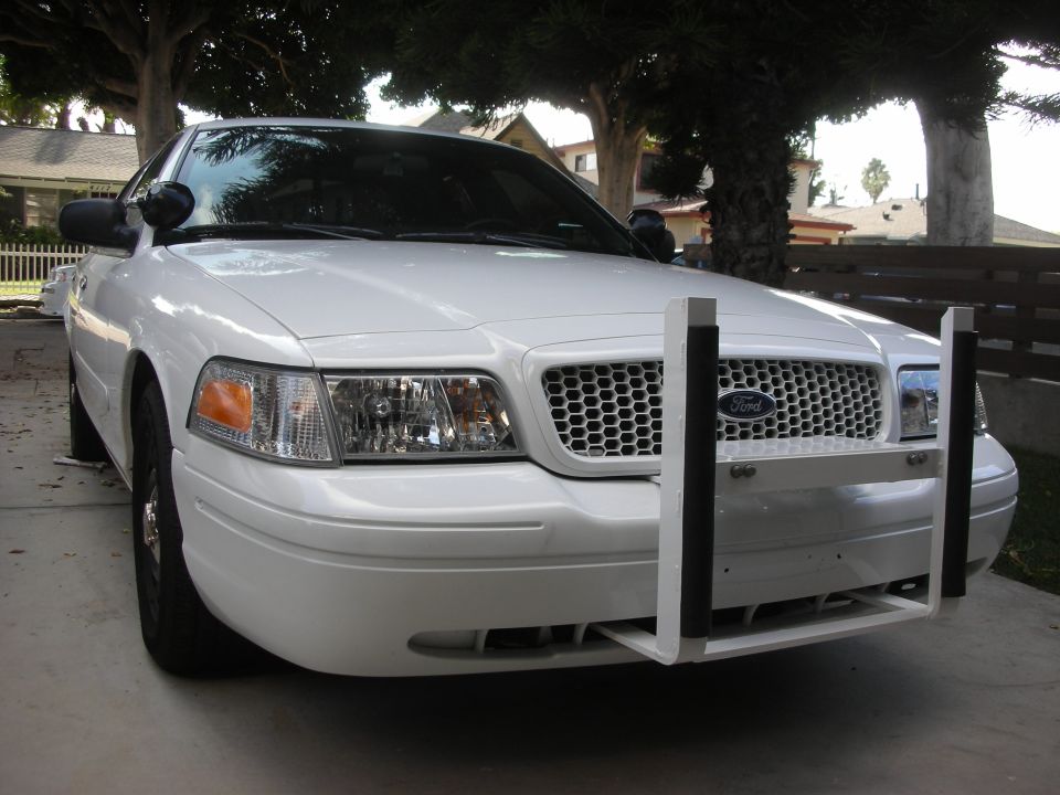 White Ford Crown Victoria 3/4 front view with white push bumper and black steel wheels