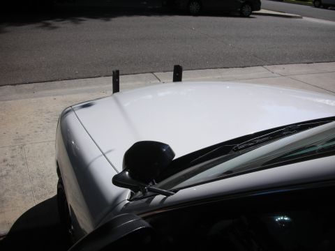 2004 Ford Crown Victoria - A white 2004 Ford Crown Victoria is seen from a high angle, focusing on the hood and windshield area.