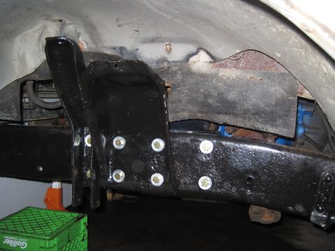 1979 Ford Bronco - Close-up view of vehicle frame and suspension components, with a green crate and orange jack in the foreground.