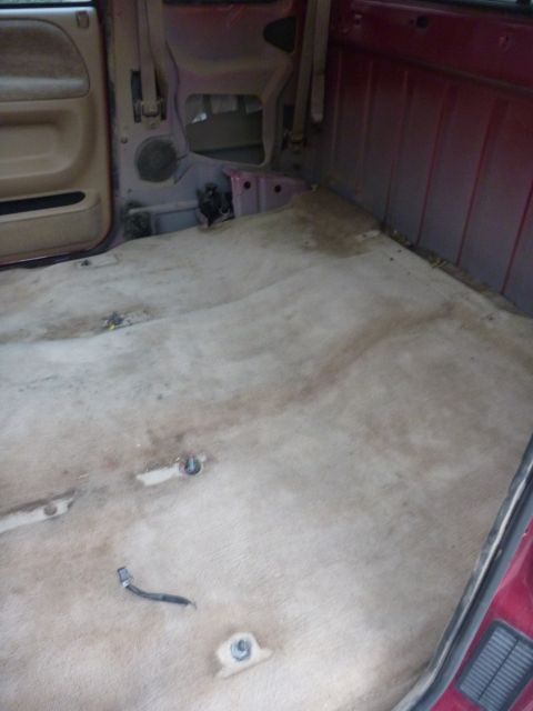 1997 Dodge 2500 - The interior of a 1997 Dodge 2500 pickup truck is shown, with exposed mounting points and worn carpeting.