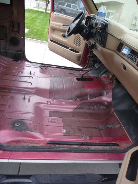 1997 Dodge 2500 - Interior of a 1997 Dodge 2500 with the carpet removed, revealing the red metal floor.
