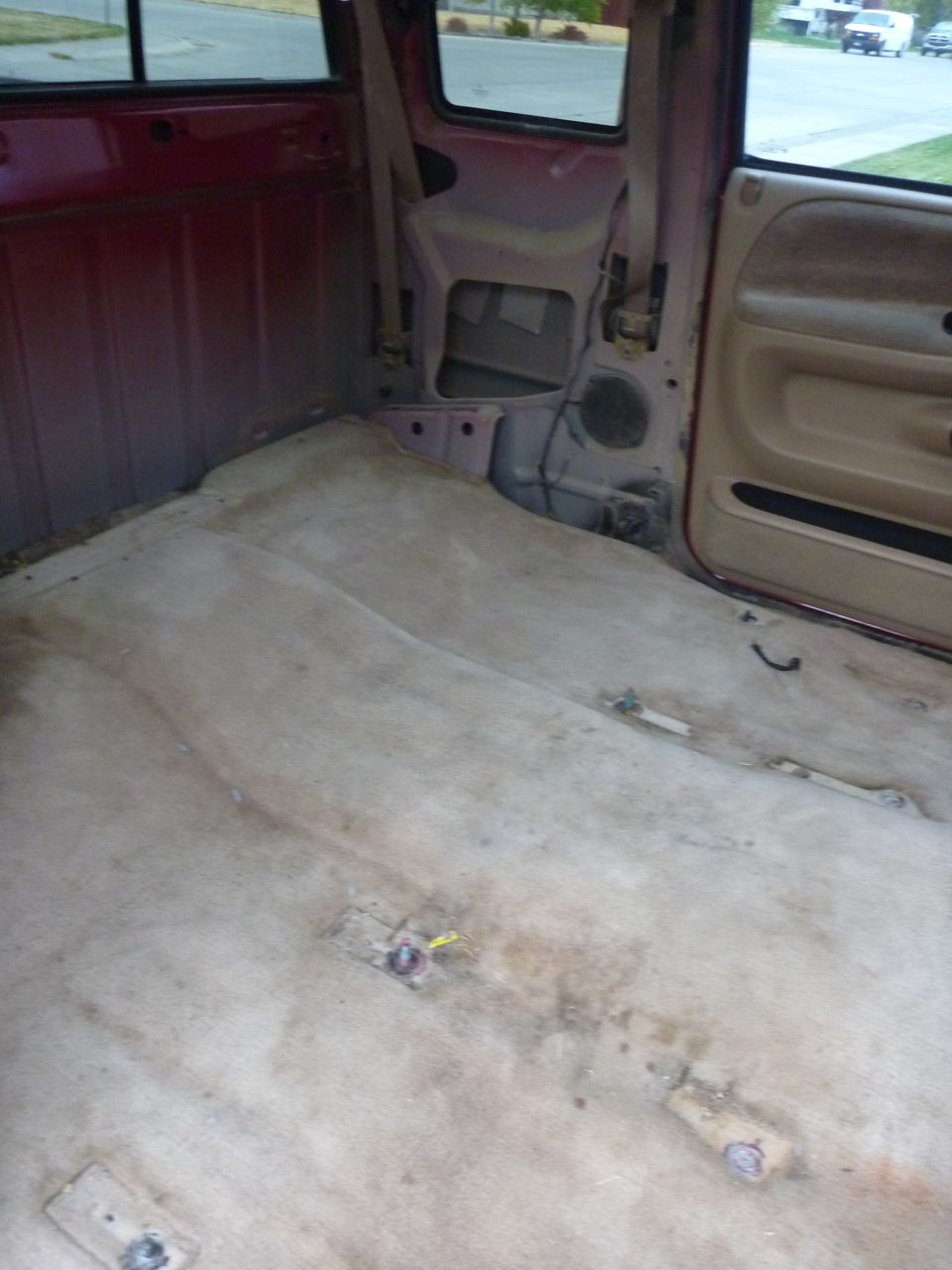 Interior of a 1997 Dodge 2500 pickup truck, showing worn tan carpet and red interior walls