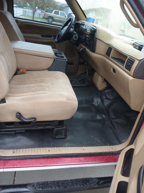 1997 Dodge 2500 - The interior of a 1997 Dodge 2500 pickup truck, tan upholstery and a dark floor mat.