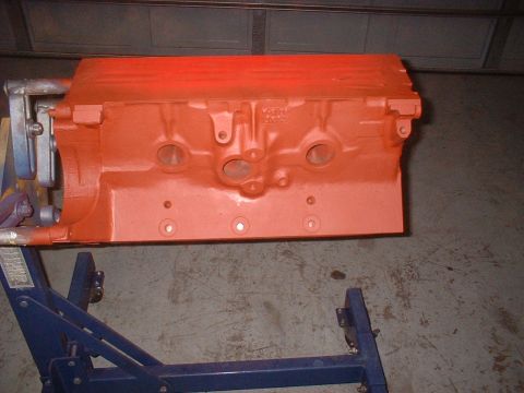 1964 Ford Galaxie - An orange engine block is mounted on a blue stand in a garage.