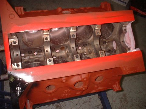 1964 Ford Galaxie - An orange engine block is shown with its bearing caps installed, ready for assembly.