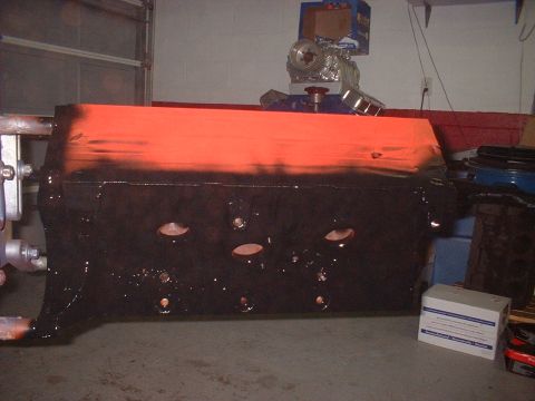 1964 Ford Galaxie - Engine block painted orange and black, with a small engine assembly in the background.