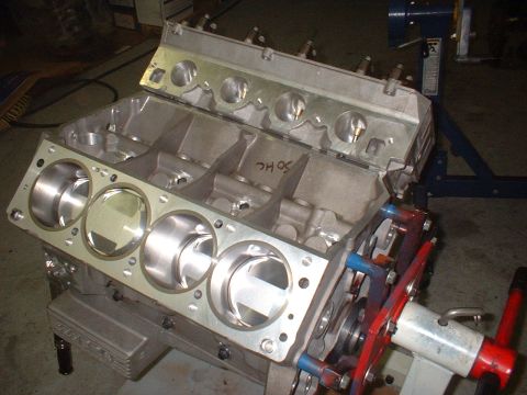 1965 Shelby Cobra - V8 engine block with pistons, mounted on an engine stand for assembly or repair.