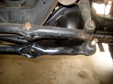 1996 Ford Bronco - Underside view of a vehicle's steering system components, including tie rods and ball joints.