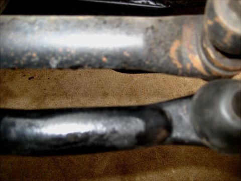 1996 Ford Bronco - Two metal steering linkage components are shown in a close-up view, one appearing older and rusted.