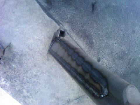 1986 Ford Bronco - Close-up of a welded metal component, possibly a suspension part, on a workshop floor.