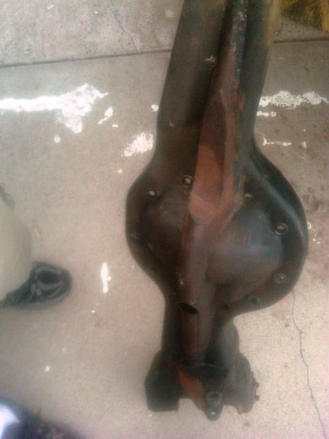 1986 Ford Bronco - A close-up view of a rear axle differential part resting on a concrete surface.