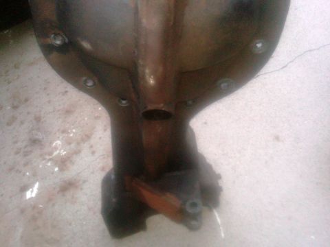 1986 Ford Bronco - Differential housing part shown from below, with visible rust and bolt holes.
