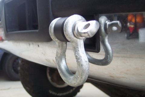 1995 Ford Bronco - Metal tow hitch shackle mounts are visible on the rear of a vehicle.