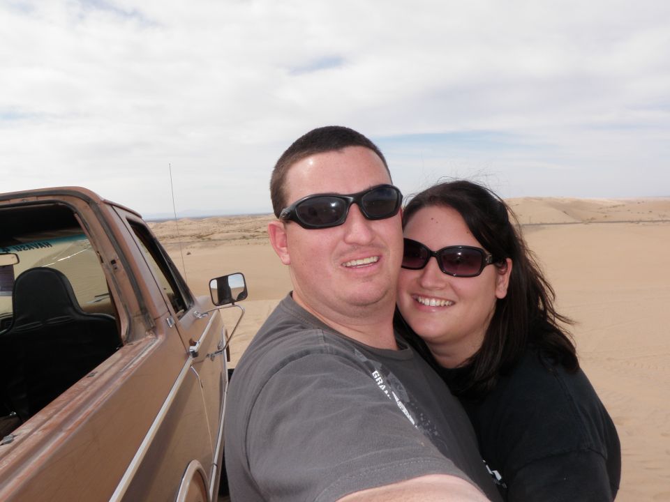 Brown truck side view with couple in desert