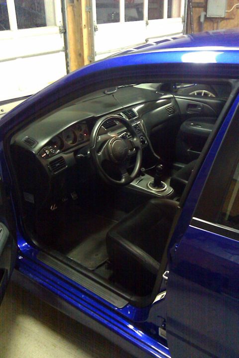 2006 Mitsubishi Evolution - Interior view of a blue Mitsubishi Lancer Evolution VIII, revealing the dashboard, steering wheel, and seats.
