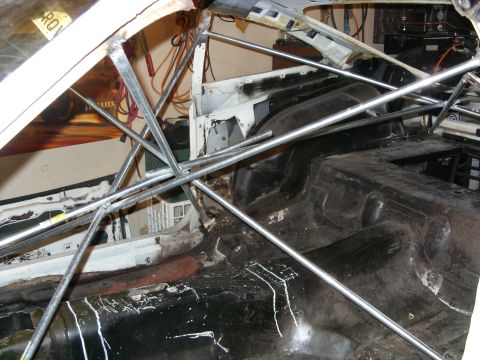 1978 Ford Mustang II - The interior of a car is visible, showing a roll cage and stripped-down components.