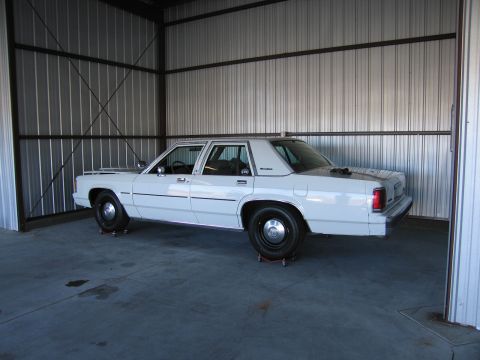 1991 Ford LTD Crown Victoria - Side view of a white 1991 Ford Crown Victoria LTD in a storage building.