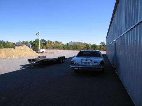 1991 Ford LTD Crown Victoria - Rear view of a 1991 Ford Crown Victoria LTD police car parked beside a corrugated metal building.