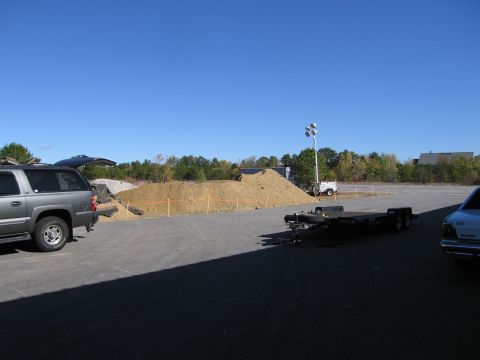 1991 Ford LTD Crown Victoria - A construction site scene with a gray SUV, a trailer, and a light tower under a clear blue sky.
