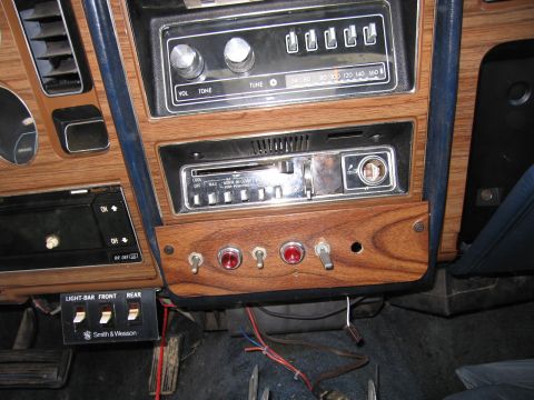 1991 Ford LTD Crown Victoria - Aftermarket switches and vintage radio installed on a car's dashboard.