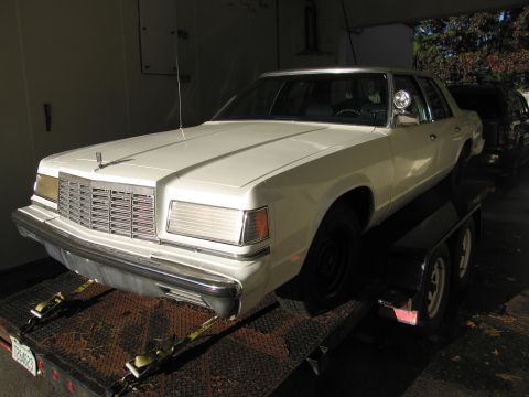 1991 Ford LTD Crown Victoria - White sedan being transported on a trailer.