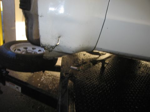 1991 Ford LTD Crown Victoria - Damage to the bottom of a car door is visible, with rust and missing paint.
