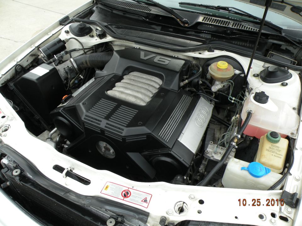 Audi V6 engine with "V6" and Audi rings visible on the cover
