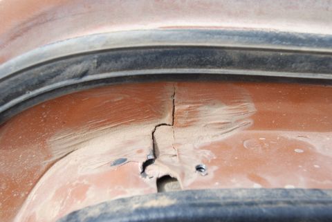 1982 Ford Bronco - A crack is visible in the orange painted metal panel, near a black rubber seal.