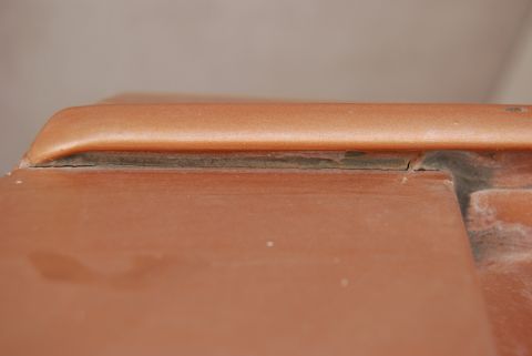 1982 Ford Bronco - A close-up view of a weathered seam on the exterior of a vehicle, revealing the underlying material.