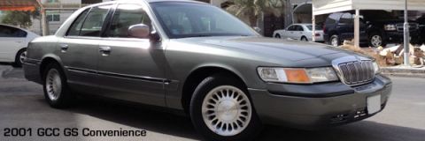 2001 Mercury Grand Marquis - Wide letterboxed signature banner showing a gray-green Mercury Grand Marquis sedan in front three-quarter view with lace-spoke alloy wheels…