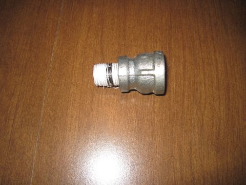 1979 Ford Bronco - A metal pipe fitting with a threaded end wrapped in white sealing tape is shown against a wooden background.