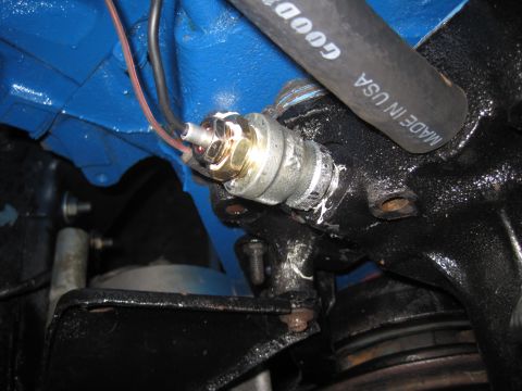 1979 Ford Bronco - Close-up of an engine component, showing a sensor and a Goodyear hose.