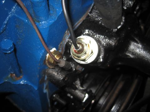 1979 Ford Bronco - A close-up view of a vehicle's engine temperature sensor and wiring.