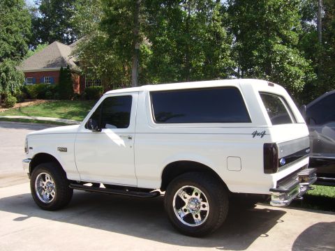 1995 Ford Bronco - This white Ford Bronco is shown from the side with aftermarket wheels and tinted windows.