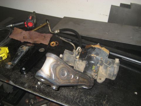 1996 Ford Bronco - A collection of steering components and tools are laid out on a workbench, possibly for repair or modification.