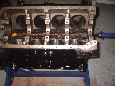1964 Ford Galaxie - Close-up of an engine block's internal components, including cylinders and camshaft, resting on a blue stand.