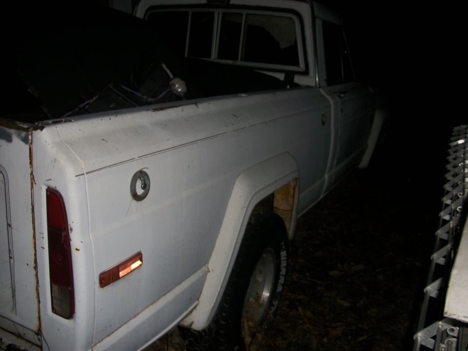 1976 Jeep J-10 pickup truck, rear quarter view, white paint, visible fuel cap
