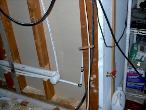 1965 Ford Mustang - Interior view of unfinished wall with plumbing and electrical work visible.