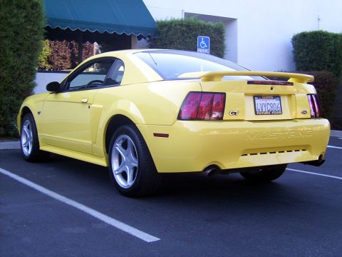 2002 Ford Mustang - Rear view of a yellow 2002 Ford Mustang GT with a spoiler and GT badging.
