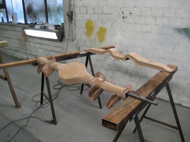 car's rear axle and frame parts on sawhorses in a workshop