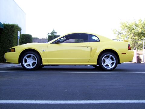 2002 Ford Mustang - Side view of a yellow 2002 Ford Mustang coupe.