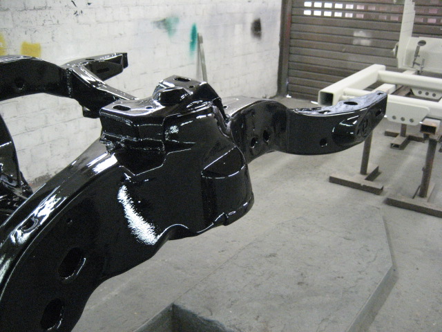 Black painted vehicle frame in a workshop
