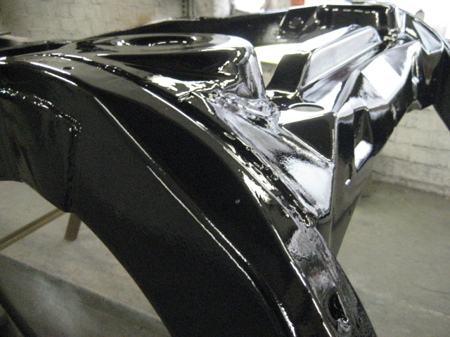 Black painted vehicle frame section with glossy finish