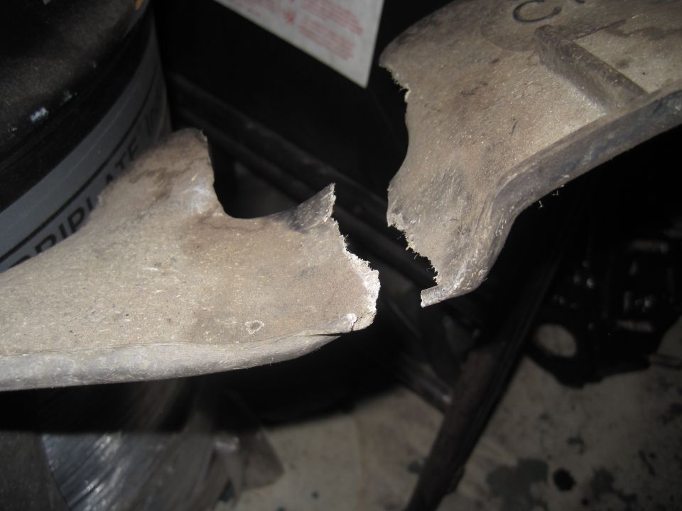 Broken metal casting, appears to be a vehicle part, in two pieces