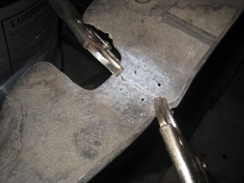 1979 Ford Bronco - Close-up of an engine component secured by vise grips, with some text visible on a container in the background.