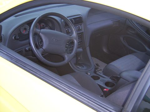 2002 Ford Mustang - The interior of a 2002 Ford Mustang, showing the dashboard, steering wheel, and seats.