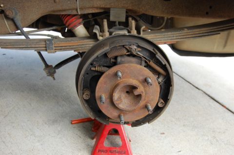 1994 Ford Bronco - The rear drum brake assembly of a 1994 Ford Bronco is visible, supported by a red jack stand.